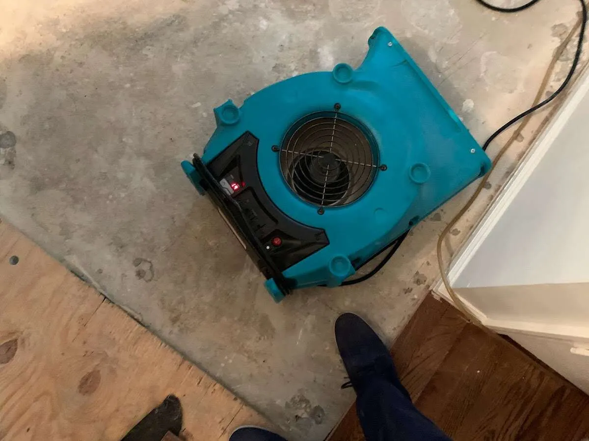 Air mover drying subfloor during Commercial Water Damage Restoration in East Bradford